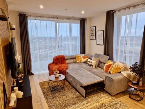 a living room with a couch and a large window at Wembley Cozy Cloud Waterfront Retreat with Parking near Wembley stadium in London