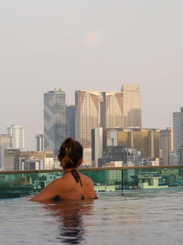 a woman in the water with a city in the background at CHECK inn Phnom Penh Royal Palace in Phnom Penh