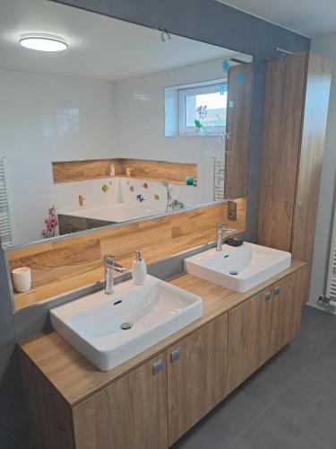 a bathroom with two sinks and a large mirror at H apartment in Jankov