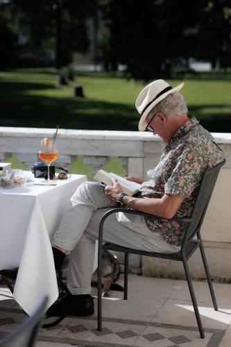 an older man sitting in a chair at a table at Hotel Villa La Bollina in Serravalle Scrivia