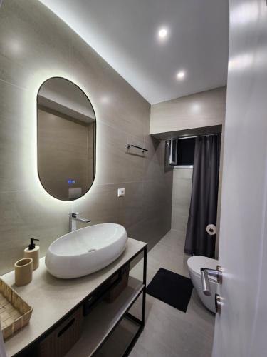 a bathroom with a white sink and a mirror at Feel like home 2 in Shkodër