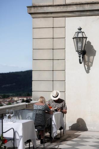 two people sitting at a table at a restaurant at Hotel Villa La Bollina in Serravalle Scrivia
