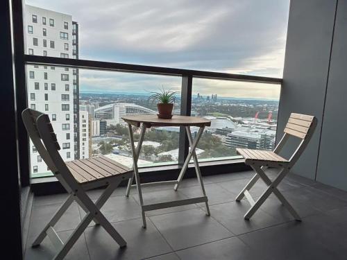 a table and two chairs on a balcony with a view at Luxury Sky Escape in Sydney Olympic Park in Sydney