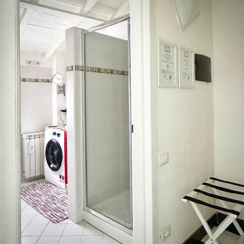 a laundry room with a washing machine and a glass door at Appartamento Cà Insulae in Luni