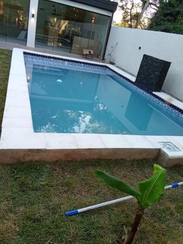 a swimming pool in a yard next to a house at Alojamiento de Samber Nuevo y Moderno in San Bernardino