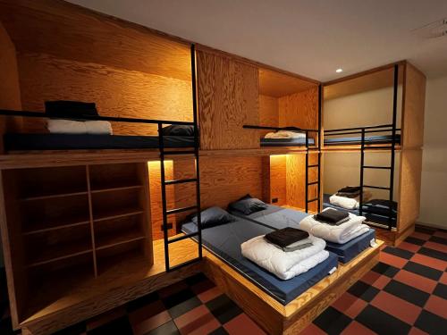 a room with two bunk beds and a checkered floor at Horizon Hostel in Bredene