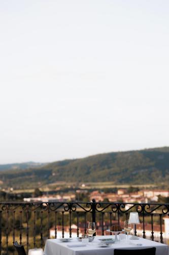 a table with white linen and wine glasses on a balcony at Hotel Villa La Bollina in Serravalle Scrivia