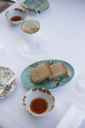 a table with a plate of bread and a glass of wine at Hotel Villa La Bollina in Serravalle Scrivia