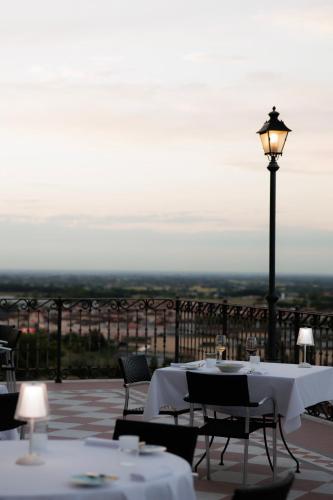 a restaurant with tables and a street light on a balcony at Hotel Villa La Bollina in Serravalle Scrivia
