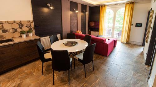 a living room with a table and a pink couch at Norweska Dolina Family&Pet-friendly Resort in Szklarska Poręba