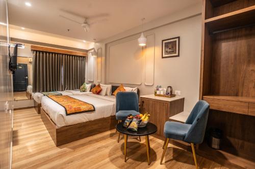 a hotel room with a bed and a table and chairs at Hotel Lake Metro in Udaipur