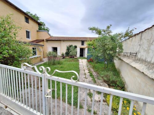 a white fence in front of a house at Maison atypique in Vougy