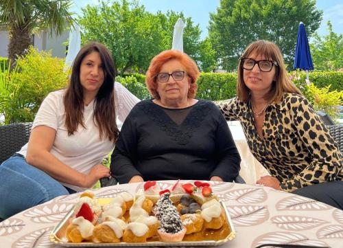 three women sitting at a table with a plate of food at Hotel Bolero in Sirmione