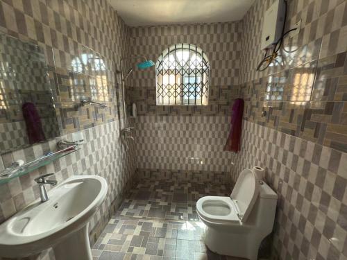 un baño con lavabo e inodoro en Apartment in Tema, en Afienya