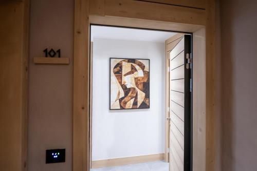 a door leading into a hallway with a painting on the wall at BiancaNeve Jahorina in Jahorina
