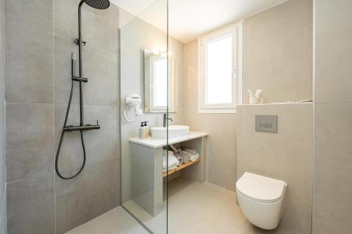 a bathroom with a shower and a toilet and a sink at Gloria Luxury Suites in Kallithea Halkidikis