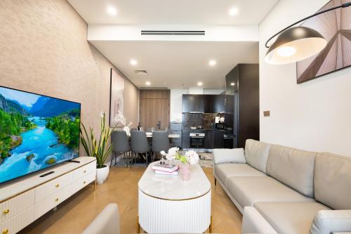 a living room with a couch and a tv at Lumiere Riverside Heera Stay Apartment in Ho Chi Minh City