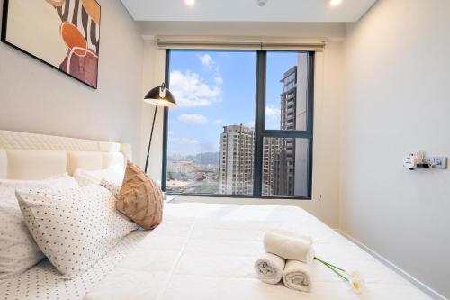 a bedroom with a bed and a large window at Lumiere Riverside Heera Stay Apartment in Ho Chi Minh City