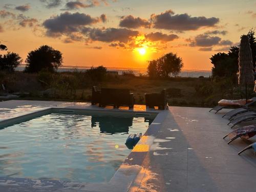 a swimming pool with a sunset in the background at Villa Priscilla in Cinisi