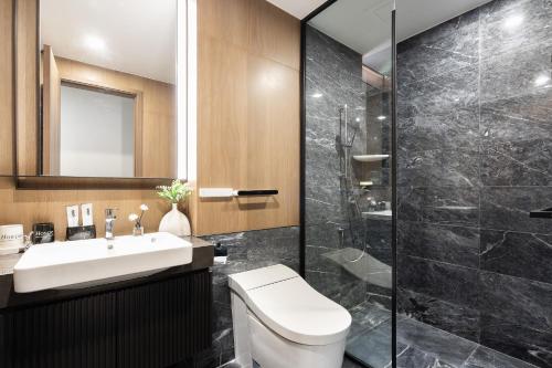 a bathroom with a toilet and a sink and a shower at Lumiere Riverside Heera Stay Apartment in Ho Chi Minh City