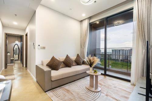 a living room with a couch and a large window at Lumiere Riverside Heera Stay Apartment in Ho Chi Minh City