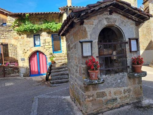 a stone building with two potted plants on it at Bienvenue chez nous in Cardaillac