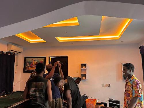 a group of men standing in a room adjusting a ceiling at Prime Apartnent in Alagbado
