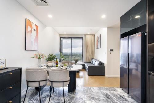 a kitchen and living room with a table and chairs at Lumiere Riverside Heera Stay Apartment in Ho Chi Minh City