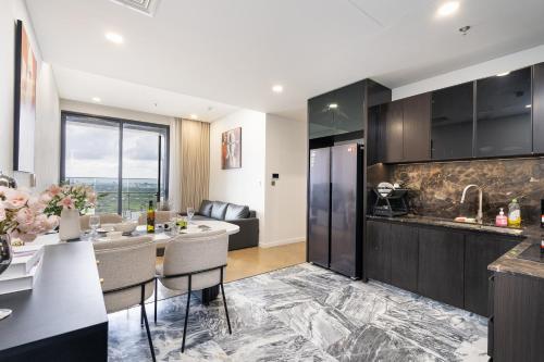 a kitchen and living room with a table and chairs at Lumiere Riverside Heera Stay Apartment in Ho Chi Minh City