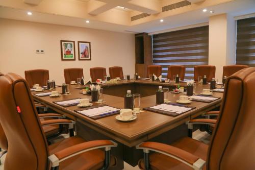 a conference room with a long table and chairs at Efcee Sarovar Premiere Bhavnagar in Bhavnagar