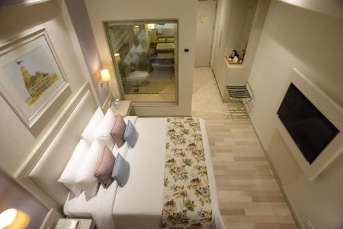 a room with a bed with pillows on it at Efcee Sarovar Premiere Bhavnagar in Bhavnagar