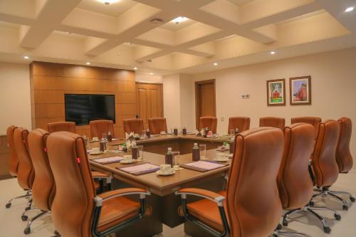 a conference room with a large table and chairs at Efcee Sarovar Premiere Bhavnagar in Bhavnagar