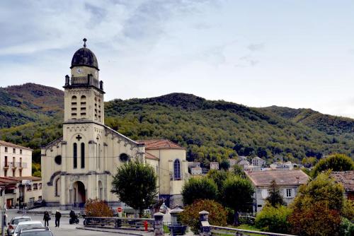 a building with a clock tower in a town at A Casa D'amore in Bastelica