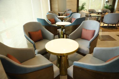 a row of chairs and tables in a waiting room at Efcee Sarovar Premiere Bhavnagar in Bhavnagar