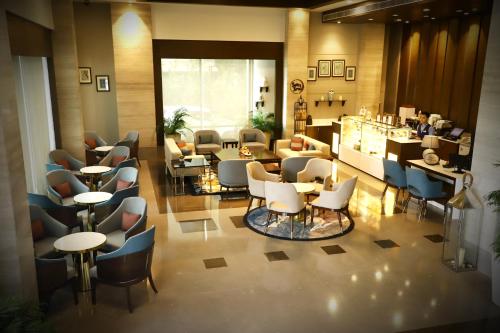 a restaurant with chairs and tables in a lobby at Efcee Sarovar Premiere Bhavnagar in Bhavnagar