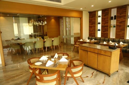 a restaurant with tables and chairs and a dining room at Efcee Sarovar Premiere Bhavnagar in Bhavnagar
