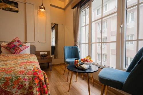 a room with a bed and two chairs and a window at Hotel Lake Metro in Udaipur