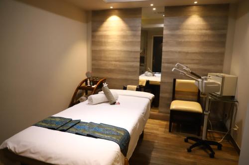 a bedroom with a bed and a desk and a chair at Efcee Sarovar Premiere Bhavnagar in Bhavnagar