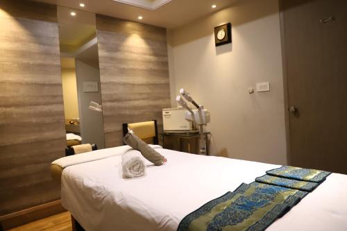 a hospital room with a bed and a mirror at Efcee Sarovar Premiere Bhavnagar in Bhavnagar