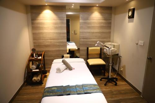 a hospital room with two beds and a mirror at Efcee Sarovar Premiere Bhavnagar in Bhavnagar