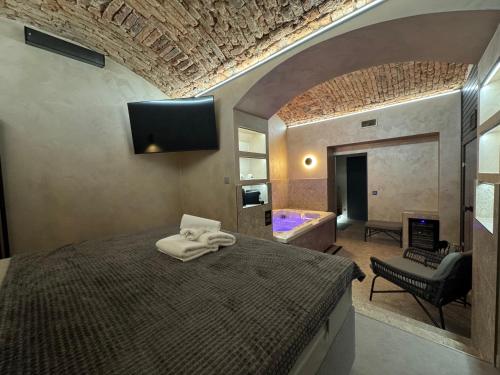 プラハにあるSPA SPA Karlínのベッドルーム(ベッド1台、テレビ、バスタブ付)