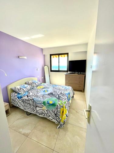 une chambre avec un lit et une télévision dans l'établissement Vue Mer exceptionnelle au Grand Duc - Calme - Clim - garage, à Mandelieu-la-Napoule