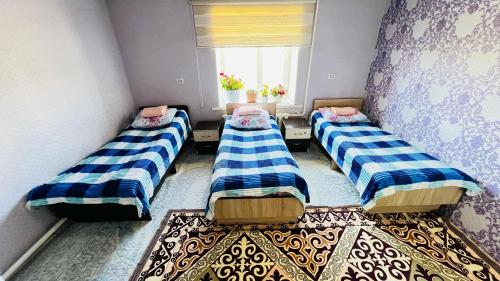 three beds in a room with a window at Mira Guest House in Kyzart