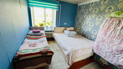 a small room with two beds and a window at Mira Guest House in Kyzart