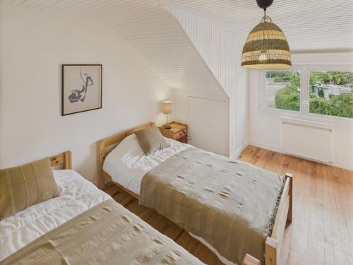 a bedroom with two beds and a window at 300m plage - maison pour 7 avec grande terrasse in Penmarcʼh