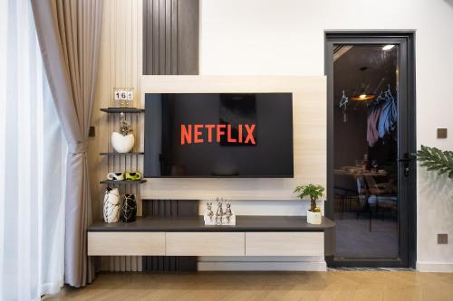 a television on a wall in a room at Lumiere Riverside Heera Stay Apartment in Ho Chi Minh City