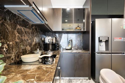 a kitchen with a sink and a refrigerator at Lumiere Riverside Heera Stay Apartment in Ho Chi Minh City