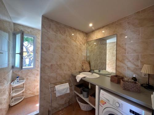 a bathroom with a sink and a washing machine at Les oliviers 11 Appartement, bord de mer, porto-vecchio in Porto-Vecchio