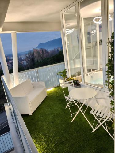 a balcony with a white couch and a table and chairs at Asso Residence Gold in Terni