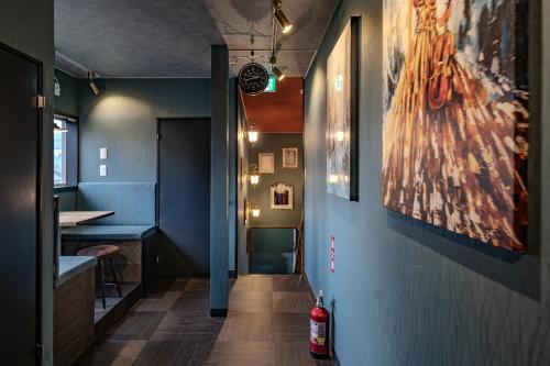 a hallway with blue walls and a painting on the wall at 草津温泉湯畑 徒歩圏内 &温泉街を大勢で遊びたい & 癒されたい in Kusatsu